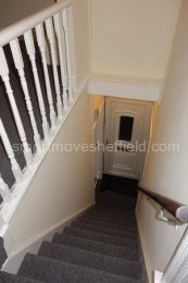 Main stairs from first floor landing showing front door